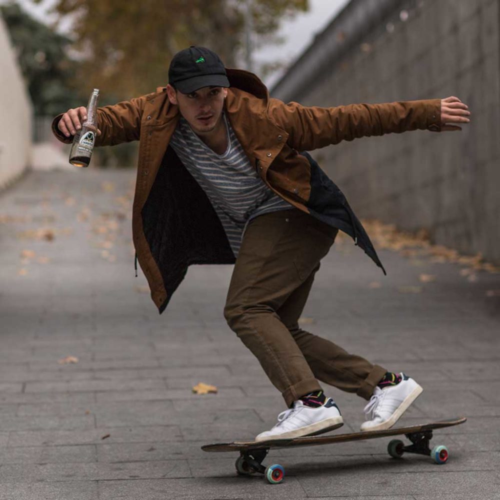 chico y su skateboard sosteniendo un refresco de cola marca Jarritos